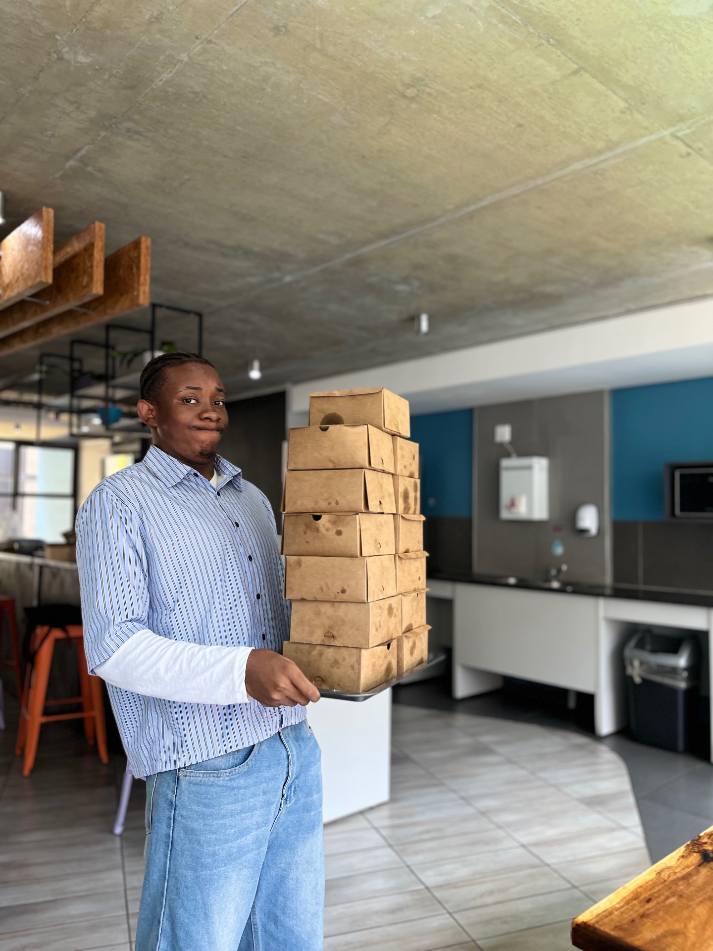 Kudzi holding a stack of freshly packed cookie boxes